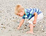 Boy gathering rocks at beach