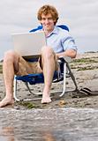 Man using laptop at beach