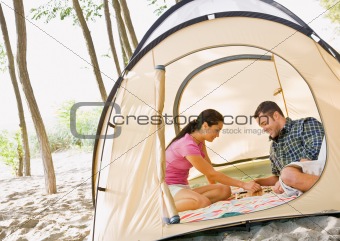 Couple playing boardgame in tent