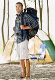Man carrying backpack at campsite