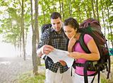 Couple in backpacks looking at map