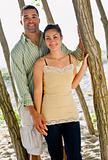 Couple leaning on tree at beach