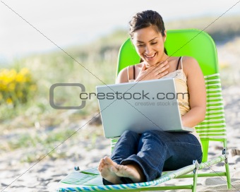 Woman using laptop at beach