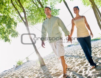 Couple walking holding hands at beach