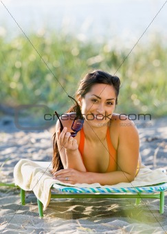 Woman laying on lounge chair at beach