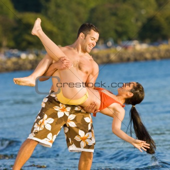 Boyfriend lifting girlfriend on beach
