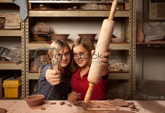 Young girls with tools in clay studio