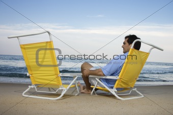 Man Sitting on Beach Alone