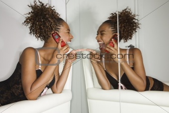 Attractive Young Woman Holding Cell Phone and Laughing