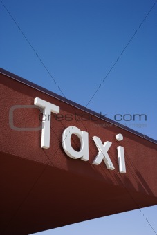 Taxi Sign On a Brown Wall