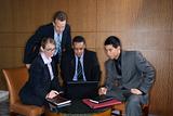 Businesspeople Gathered Around a Laptop