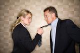 Angry Businesswoman Pulling Man's Tie