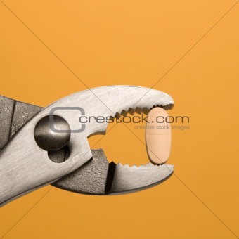 Pill Gripped With Pliers. Isolated
