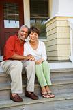 Couple Sitting on Outdoor Steps of Home Smiling