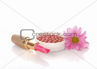 New lipstick and pink flower on white background