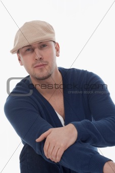 young handsome man with cap, sitting, isolated on white