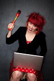 Pretty punky girl with brightly dyed red hair with laptop computer