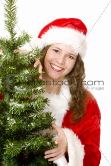 Young smiling Santa Woman standing beside Christmas tree 