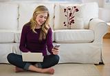 female in livingroom with laptop and cell phone