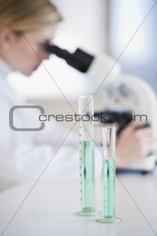 test tubes with scientist in the background
