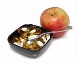 Fuji apple with pills and spoon