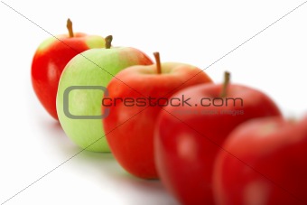 Group of red apples with one green one