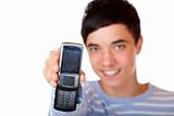 Young handsome happy smiling male teenager shows mobile phone