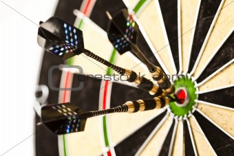 Cut image of dart pierced on target over dartboard