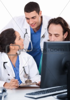 Young doctors team discussing and making notes from computer