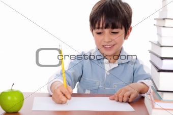 School boy doing his homework with an apple beside him