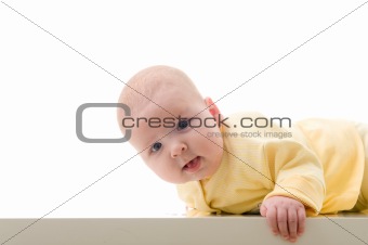 Young baby boy creeps on a table