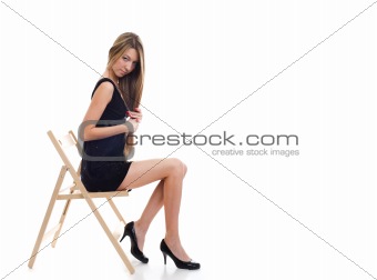 Young blonde girl sitting on a chair