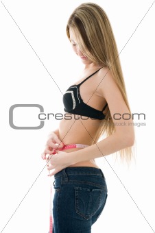 Beautiful girl measuring her waist