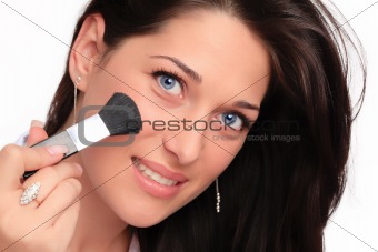 Beautiful brunette woman doing makeup
