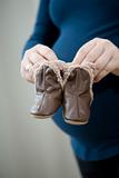 Pregnant mother holding baby booties
