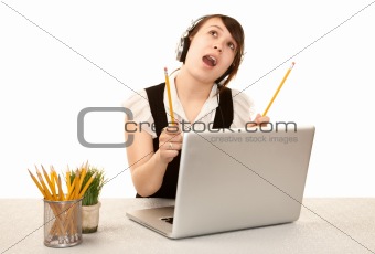 Pretty female office worker with laptop computer and headphones