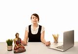 Pretty young woman meditating at her desk