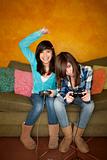Cute Hispanic Girls Playing a Video Game with Handheld Controllers