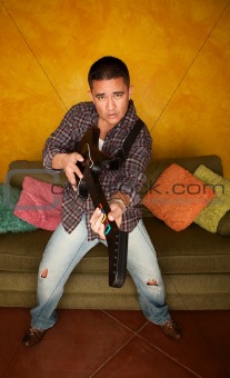 Handsome Hispanic man playing guitar based video game