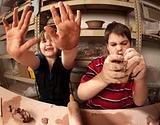 Kids with messy hands in clay studio