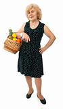 happy elderly woman with basket of fruits