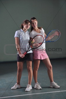 young girls playing tennis game indoor