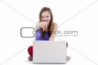 girl sitting on the floor with laptop pointing at camera smiling
