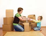 Woman and little girl in a new home unpacking 