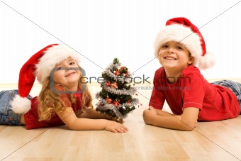 Smiling kids laying on the floor at christmas time