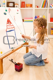 Little girl painting a house