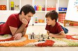 Man teaching boy the rules of chess