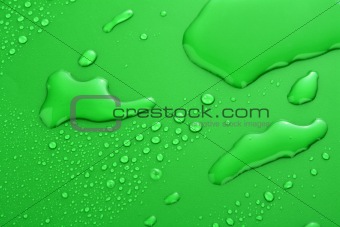 Green water drops background with big and small drops 