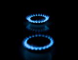 Two gas burners with flames on dark background