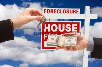 Handing Over Cash For House Keys in Front of Foreclosure Sign and Cloudy Blue Sky.